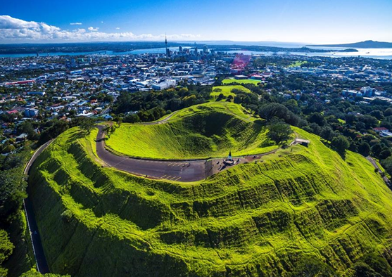 Australasian Tunnelling Conference image - Auckland skyline in the background, a large green hill in the foreground